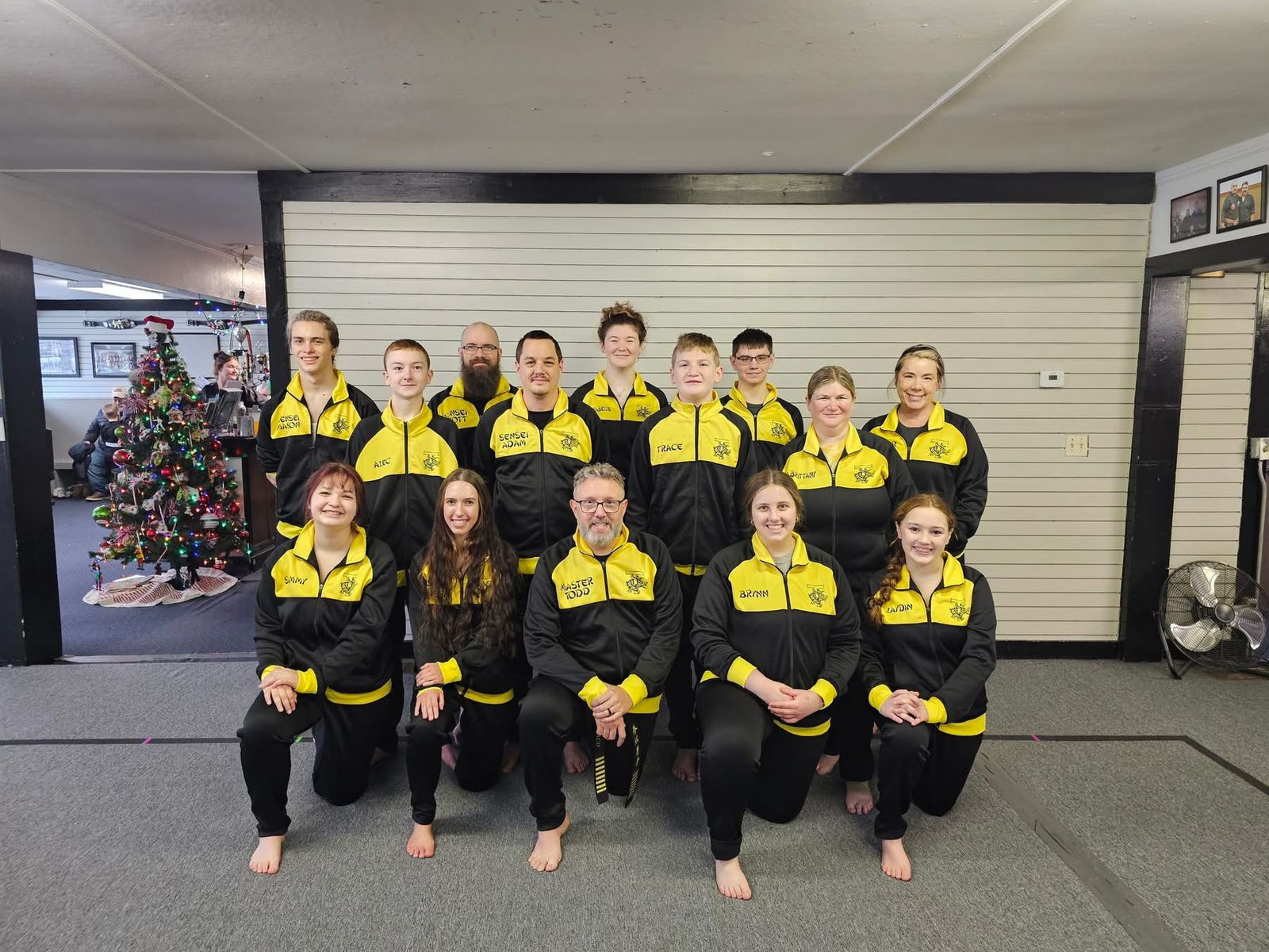 Martial arts team wearing matching yellow and black tracksuits