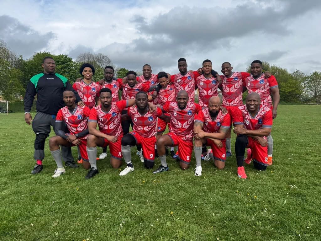 Football team posing together in red kits